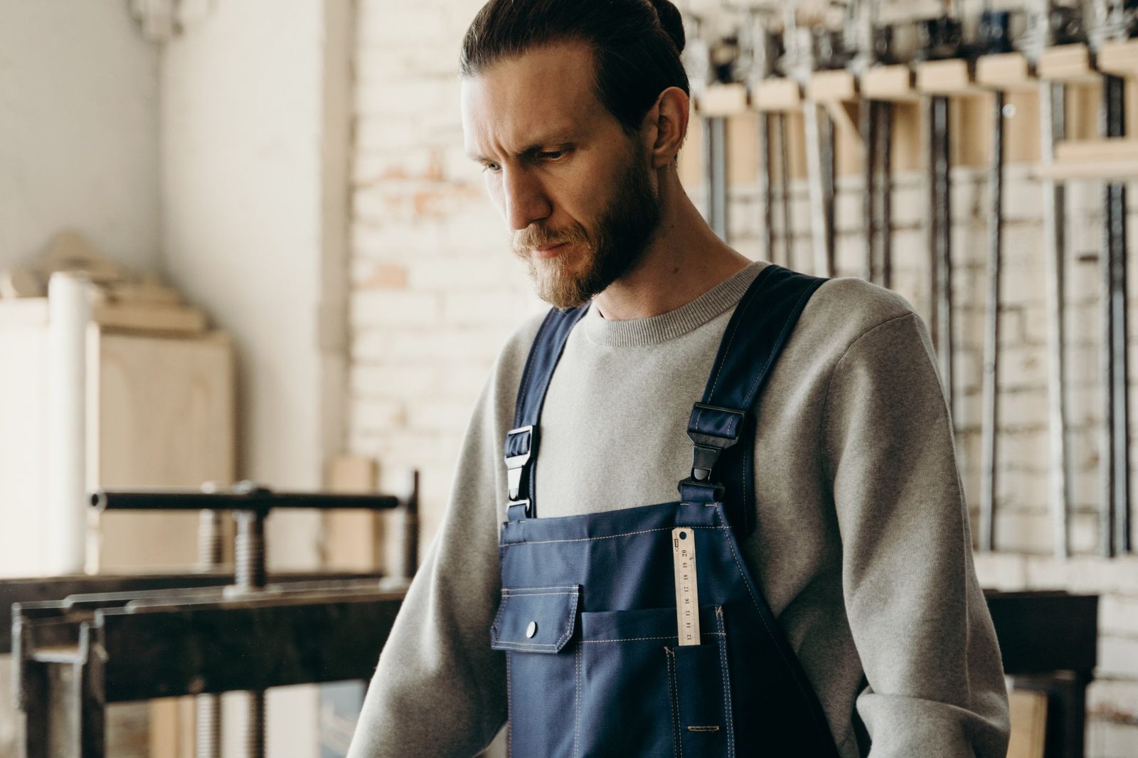 Woodworker at a workbench in a cabinet shop reviewing drawings